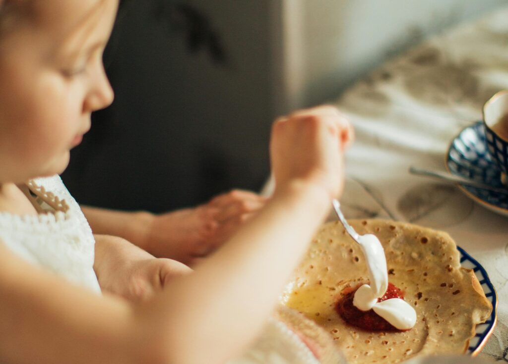 rituály v pěstounské péči: dítě si připravuje k jídlu palačinku